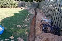 How do you dig a small drainage trench?